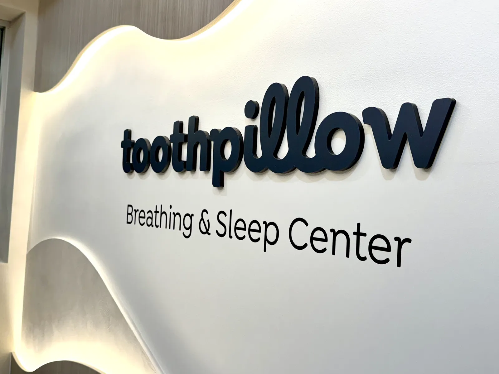Toothpillow — Backlit Lobby Sign — Halo-Lit Dimensional Letters on Sculpted Wave Panel