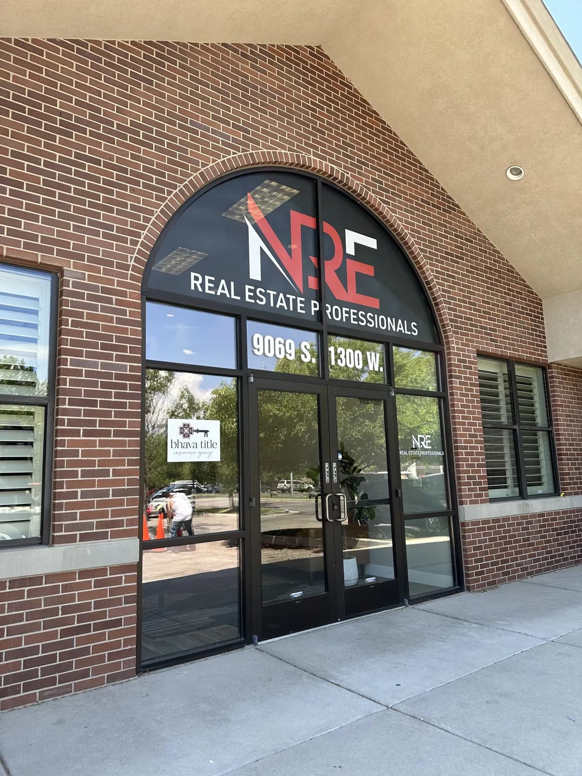 NRE Real Estate Professionals — Storefront Graphics — Arched Window Graphics and Door Lettering